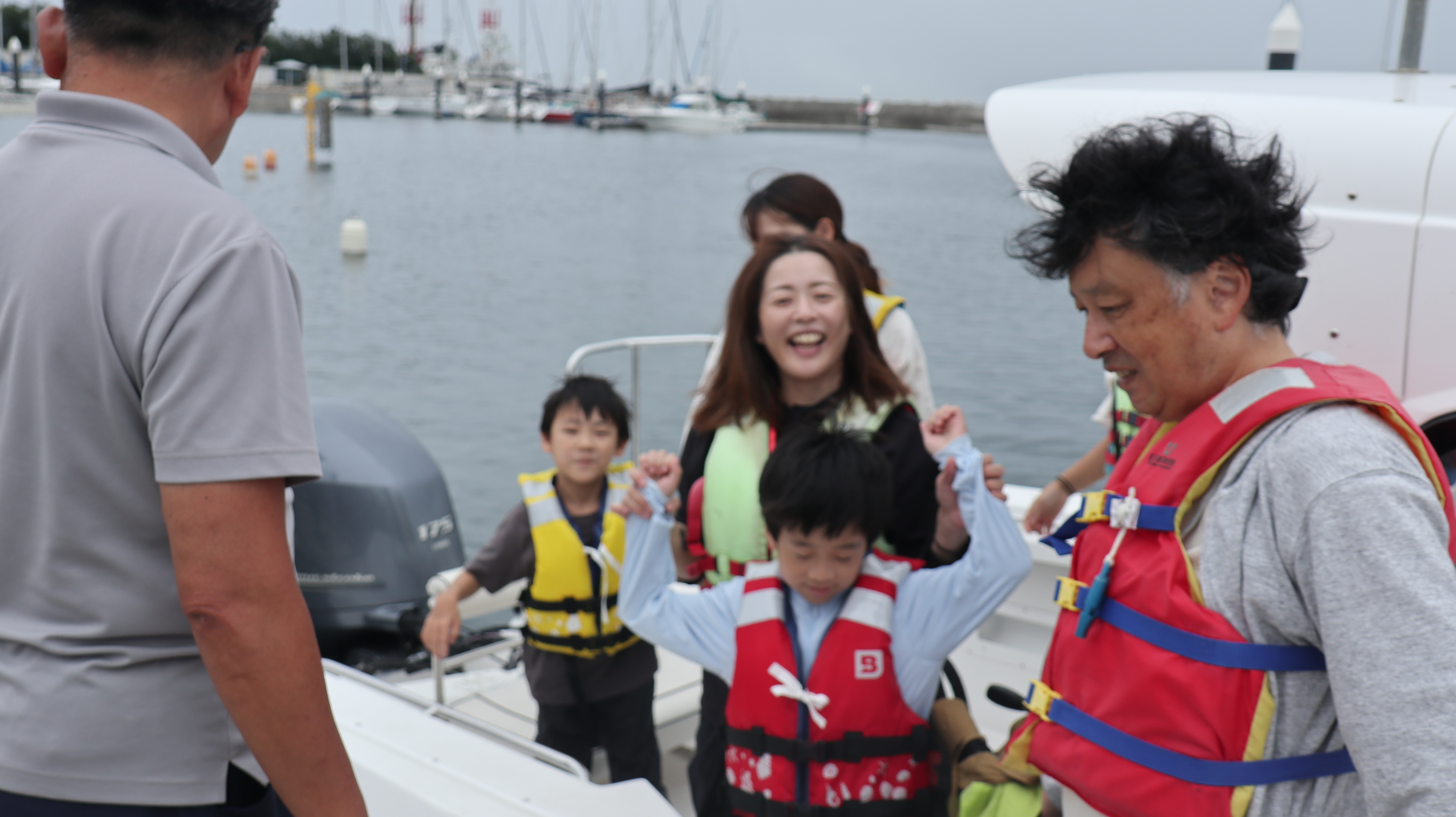 体験を終えた参加者たちが浜辺に戻り、笑顔でスタッフと挨拶。